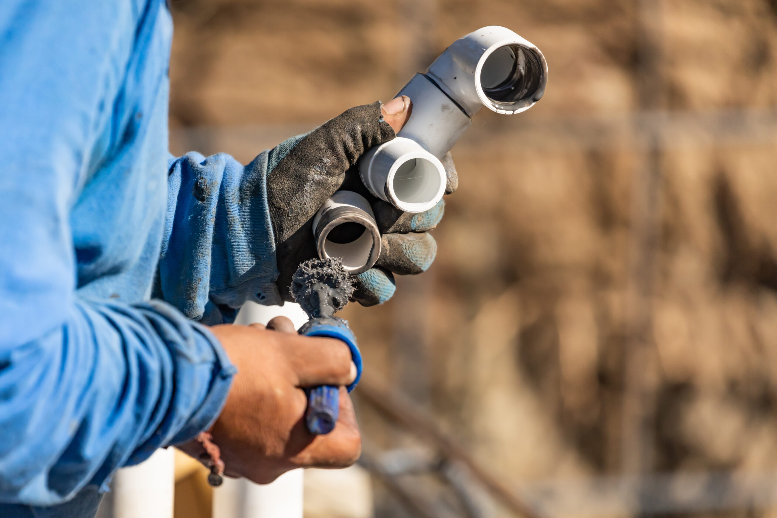 Worker handling PVC pipes at construction site